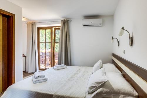 a bedroom with a bed with two towels on it at Golden Lakes Rooms in Plitvička Jezera