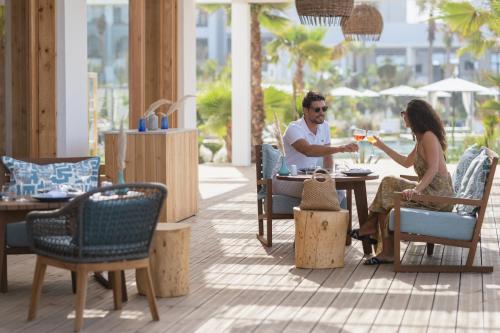 a man and woman sitting at a table drinking wine at Sofitel Agadir Thalassa Sea & Spa in Agadir