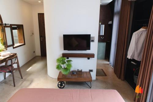 a living room with a tv on a wall at Deja Vu House Ha Long in Ha Long