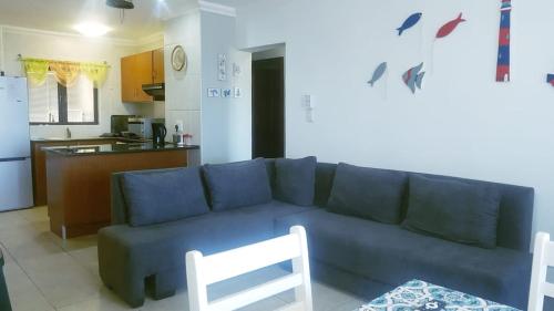 a living room with a blue couch and a kitchen at Surabaya 21 in Margate