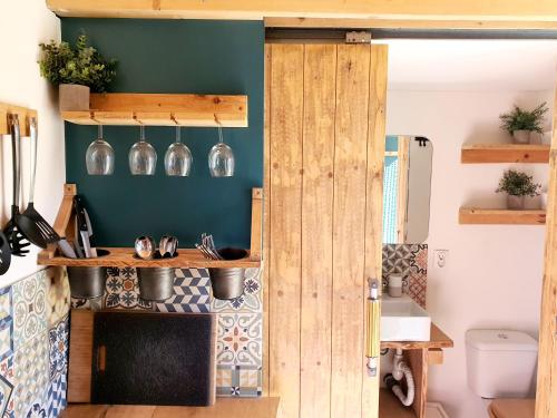 a kitchen with wooden doors and a green wall at Quinta do Castanheiro in Castanheira de Pêra