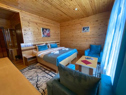 a room with a bed and a table and chairs at Kungut Hotel & Restaurant in Sheki