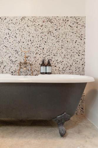 a bathtub in a bathroom with a floral wallpaper at The Dell of Abernethy - A Woodland hideaway in Nethy Bridge