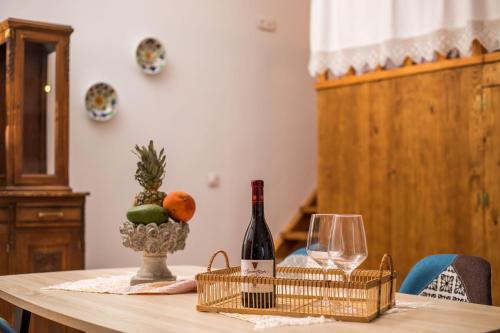 a table with a bottle of wine and a glass at Traditional Loft Casa Di Vini in Kalithies