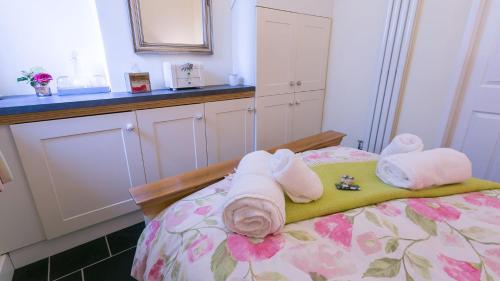 a bedroom with a bed with towels on it at Hen Bost Nefyn in Nefyn