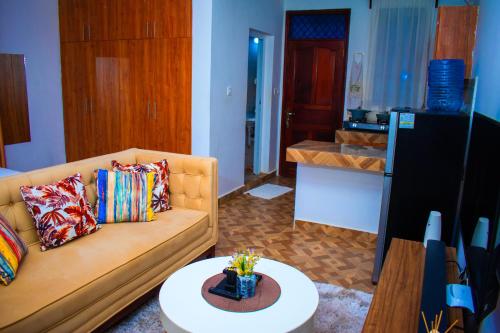 een woonkamer met een bank en een tafel bij Cambric Luxe Studio Apartment in Kilifi