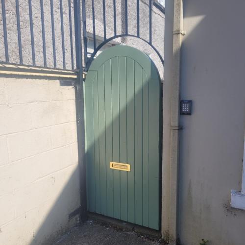 a green door on a building with a fence at Dun Maeve Guesthouse in Westport