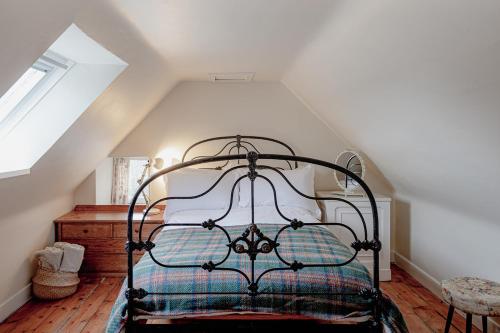 a bedroom with a wrought iron bed in a attic at The Dell of Abernethy - A Woodland hideaway in Nethy Bridge