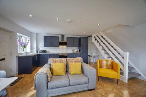 uma sala de estar com um sofá e uma cozinha em Host & Stay - The Bach em Beadnell