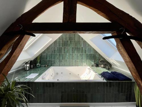 a bath tub in the attic of a house at The SPA - Voyage des sens in Amiens