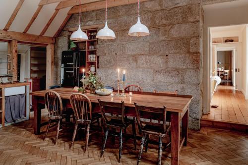 a dining room with a wooden table and chairs at The Dell of Abernethy - A Woodland hideaway in Nethy Bridge