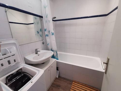 une salle de bain blanche avec un lavabo et une baignoire dans l'établissement 5008 Circé 515, au Cap d'Agde