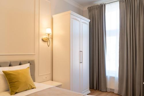 a bedroom with a white cabinet next to a window at Pensiunea Korona in Miercurea-Ciuc