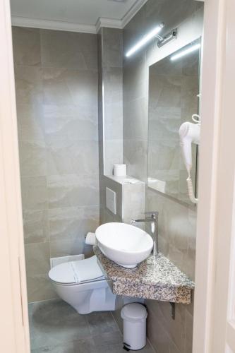 a bathroom with a sink and a toilet at Pensiunea Korona in Miercurea-Ciuc