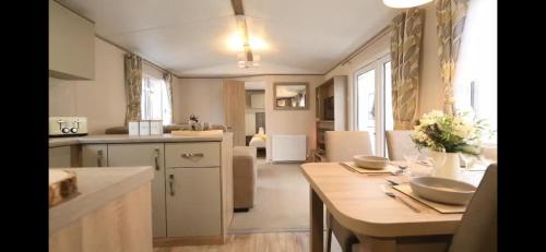 a kitchen with a table and a dining room at Fantastic Family 3-Bed static Caravan cooper bea in Colchester