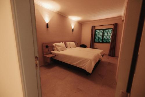 a bedroom with a white bed and a window at Casa Velha Apartments - Adults friendly in Albufeira