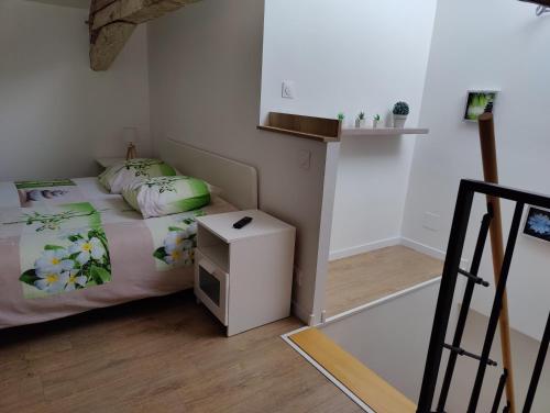 a small bedroom with a bed and a small table at Le Green Duplex moderne en hypercentre in Sarreguemines