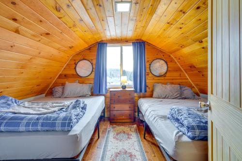 two beds in a room with a wooden ceiling at Lime Lake Cottage with Lakefront Deck and Dock! 