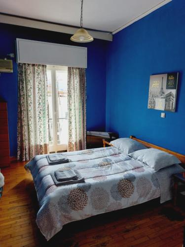 um quarto azul com uma cama e uma janela em Central Kiato em Kiato