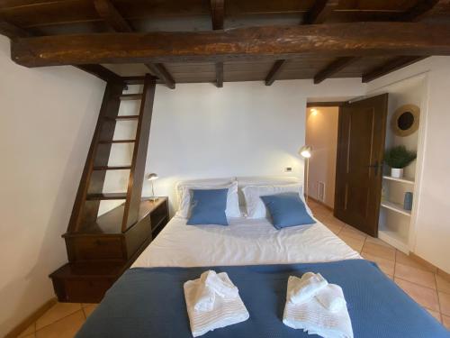 een slaapkamer met een bed met blauwe lakens en een ladder bij Appartamento Vista Lago in Anguillara Sabazia