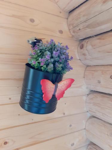 un pot bleu avec des fleurs et deux papillons sur un mur dans l'établissement sheepinn hoekje, à Tielt