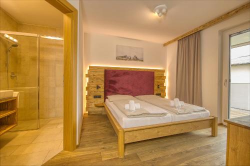 um quarto com uma cama king-size e um chuveiro em Alpin & Seeresort Top 14 - by Alpen Apartments em Zell am See