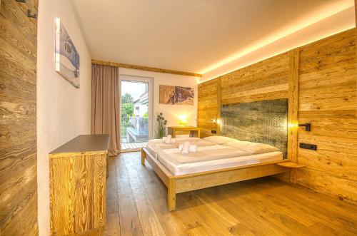 um quarto com uma cama grande e uma janela em Alpin & Seeresort Top 14 - by Alpen Apartments em Zell am See