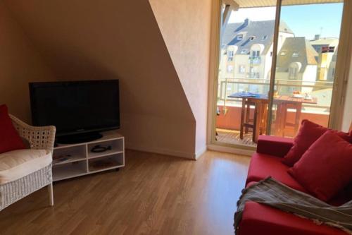 un salon avec un canapé et une télévision dans l'établissement Bright and quiet nest with terrace near beaches, à Saint-Malo