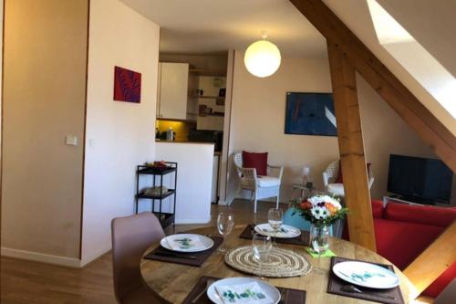 - une salle à manger et un salon avec une table dans l'établissement Bright and quiet nest with terrace near beaches, à Saint-Malo