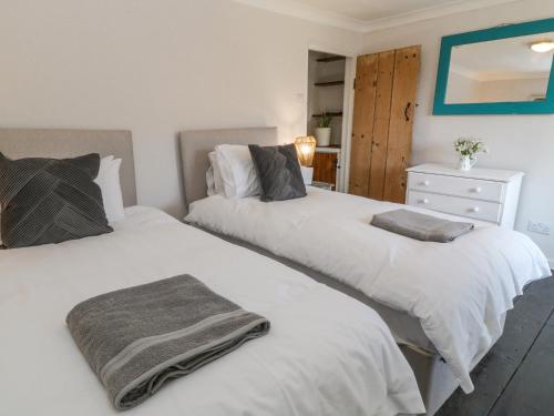 two beds in a bedroom with white sheets at Tinners in Gunnislake
