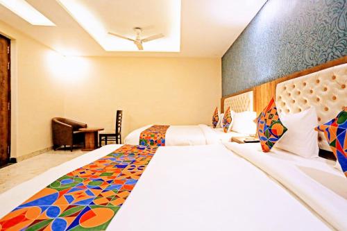 a hotel room with two beds and a desk at Mayda Inn- A Boutique Hotel in New Delhi