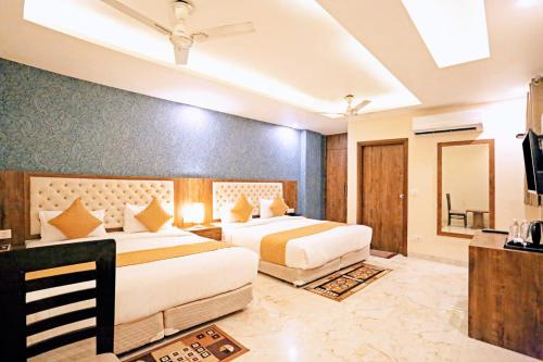 a hotel room with two beds and a television at Mayda Inn- A Boutique Hotel in New Delhi