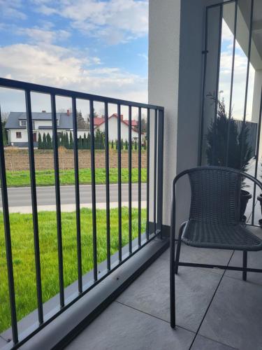 a chair on a balcony with a view of a street at Nest Niebieski in Zator