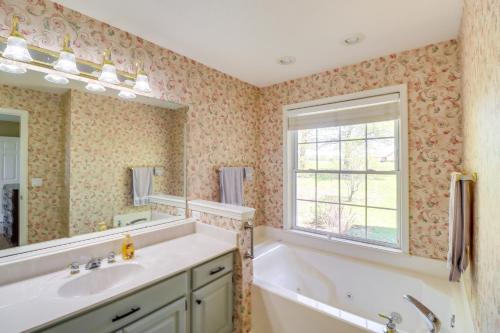 baño con bañera, lavabo y ventana en Charming Edgemont Home with Deck and Lake Views!, en Fairfield Bay