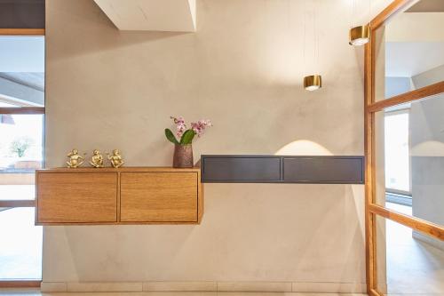 a room with a shelf and a vase of flowers on a wall at Hotel Reiler Hof in Reil