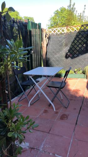 a picnic table and two chairs on a patio at La casa di Giulio in Maccarese