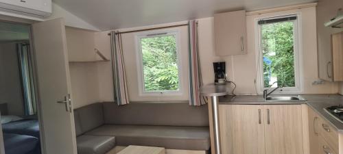 a small kitchen with a sink and two windows at MobilHome 3 chambres 6 personnes Piscine Camping Saint Cheron in Saint-Chéron