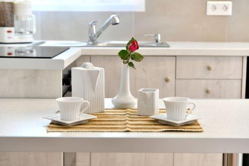 a kitchen counter with three cups and a vase with a flower at Irini's house with Jacuzzi in Dhragoulás