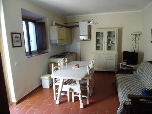 a kitchen with a white table and chairs in a room at CASA PATRIZIA MONTAIONE in Montaione