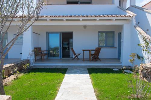 a white house with a table and chairs at ENAJA - Luxury Retreat in Budoni