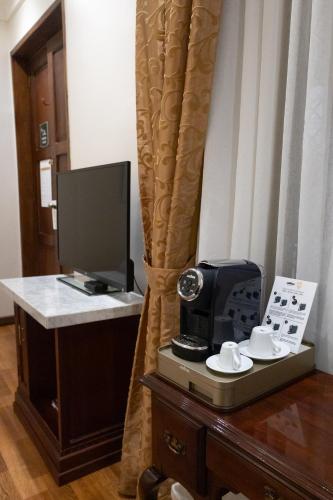 a hotel room with a desk with a television and a computer at Hotel Boutique Santa Lucia in Cuenca