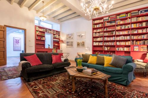 a living room with two couches and bookshelves at EXCLUSIVA CASA EN EL CENTRO HISTORICO de SEVILLA in Seville