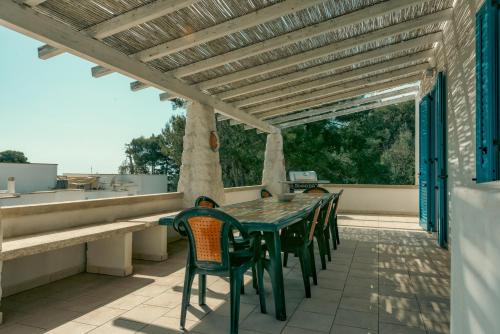 a green table and chairs on a patio at Calaluna - Villa Sea View by Diddoi in Leuca