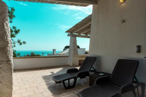 a patio with two chairs and a view of the ocean at Calaluna - Villa Sea View by Diddoi in Leuca