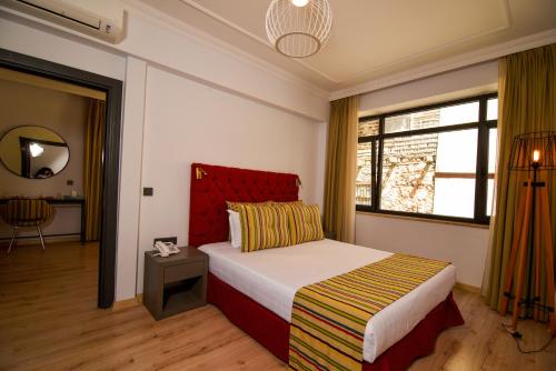 a bedroom with a bed with a red headboard and a window at Unique Flat with Balcony near Hadrian's Gate in Antalya