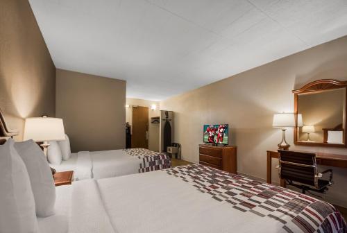 a hotel room with two beds and a mirror at Red Roof Inn and Suites Newark - University in Newark