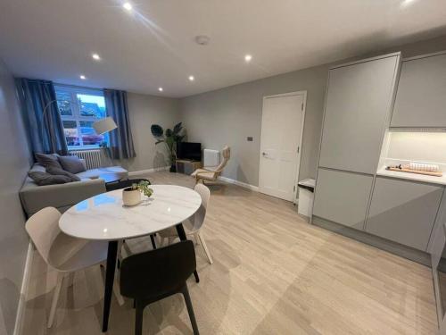 uma sala de estar com uma mesa e um sofá em Marvellous New Build 2 Bed Flat - 1 Ophelia Court em Epsom