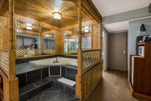 baño grande con bañera y paredes de madera. en Red Roof Inn and Suites Newark - University, en Newark