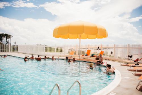 uma piscina com um grande guarda-chuva amarelo e pessoas nela em Sun Outdoors Cape Charles em Cape Charles