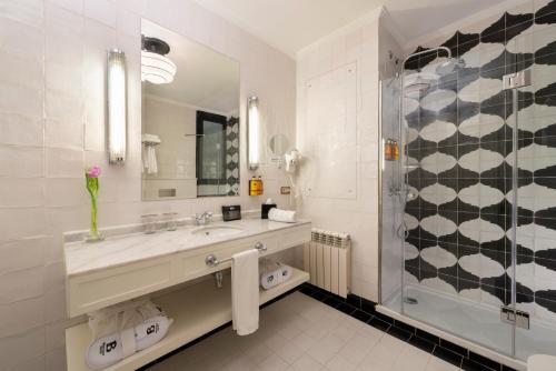 a bathroom with a sink and a shower at Boutique Hotel H10 Villa de la Reina in Madrid